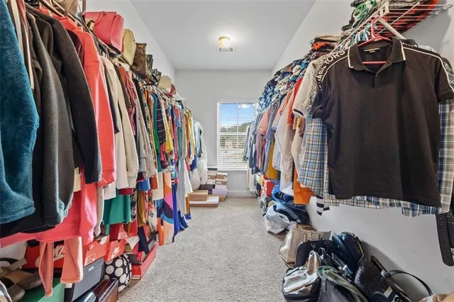 a view of walk in closet with clothes