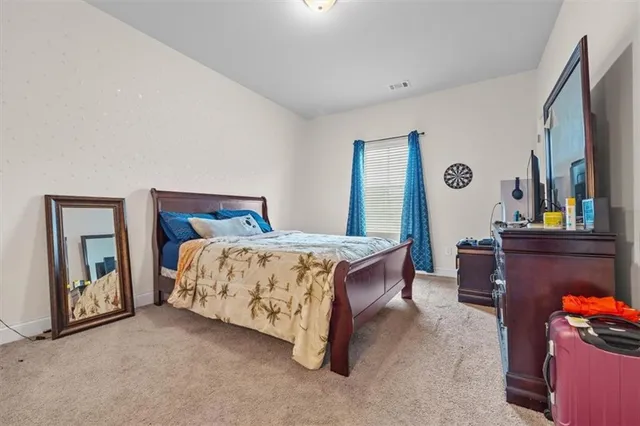 a bed sitting in a bedroom next to a window with a dresser