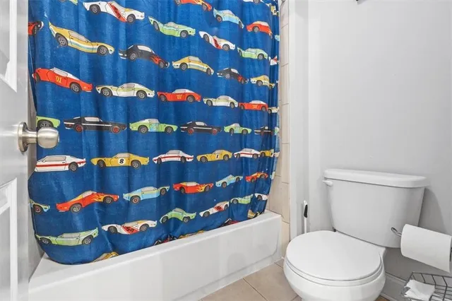 a bathroom with a toilet and a shower curtain