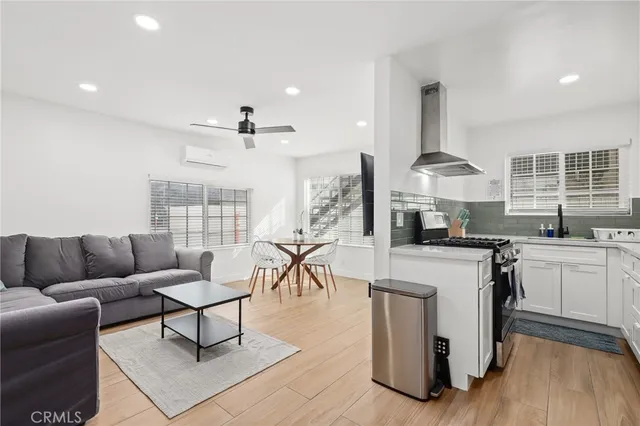 a view of a big room with wooden floor a ceiling fan and windows