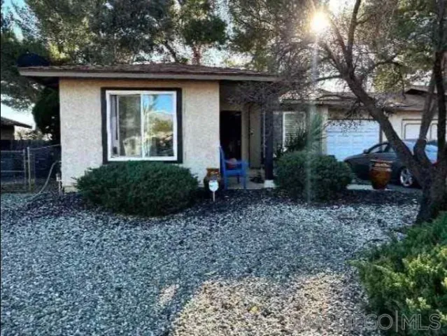 a view of a house with a yard and potted plants