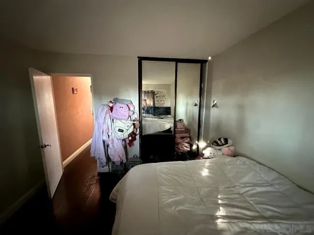 a bedroom with a bed closet and mirror