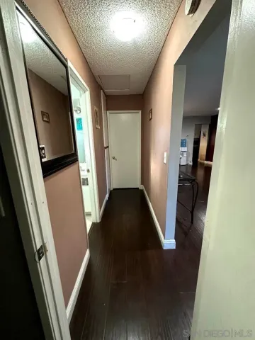 a view of a hallway with wooden floor and stairs