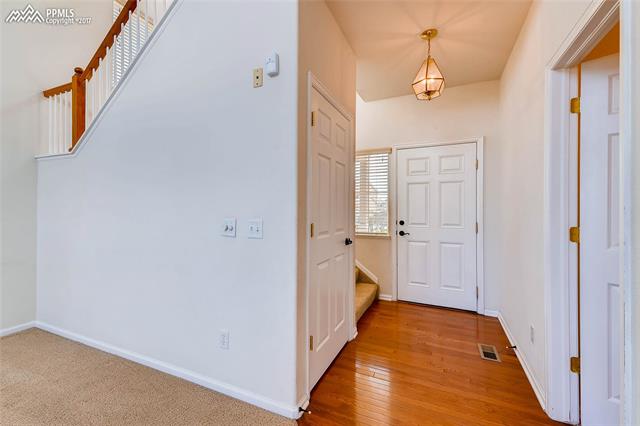 9231 Ballybunion Road Peyton, CO 80831 - Photo 5 of 26 Main level living room looking at front door with bathroom door to the right and doorway to basement to the left.