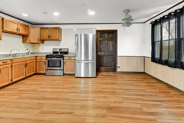 a kitchen with stainless steel appliances granite countertop a refrigerator and a stove top oven