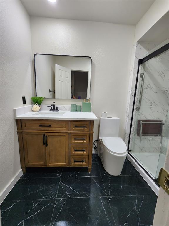 2908 Washington Street Commerce, TX 75428 - Photo 37 of 40 Contemporary bathroom featuring a wood-finish vanity with a white countertop and a black-framed mirror