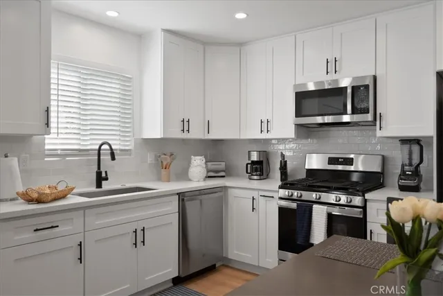 a kitchen with cabinets stainless steel appliances and a sink