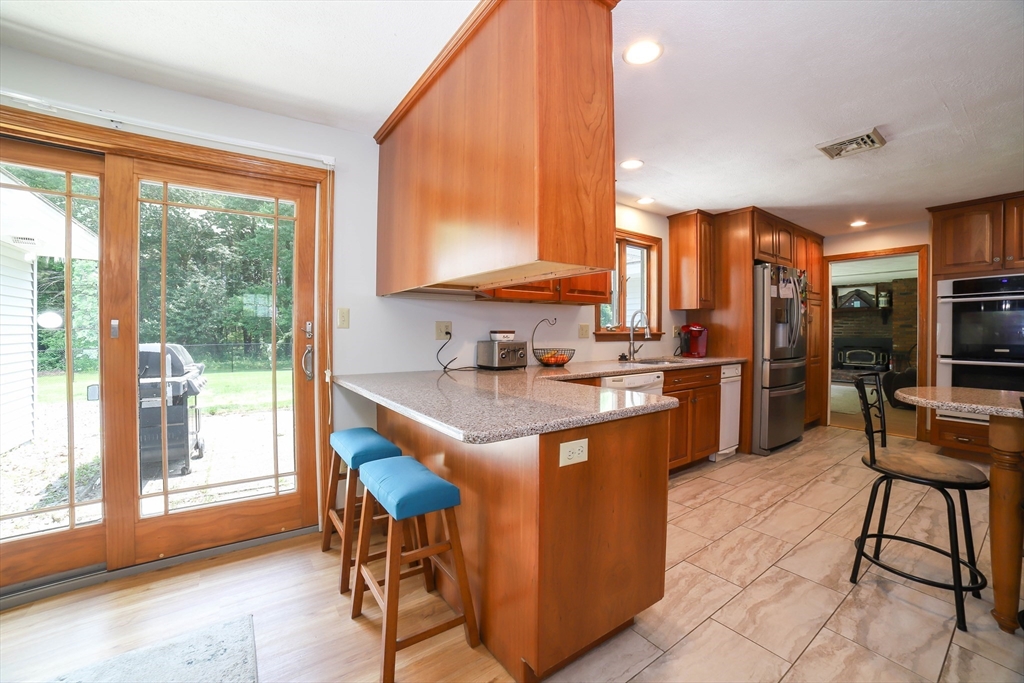 40 Old Stage Road Chelmsford, MA 01824 - Photo 7 of 34 a kitchen with stainless steel appliances granite countertop a stove top oven a sink and a refrigerator