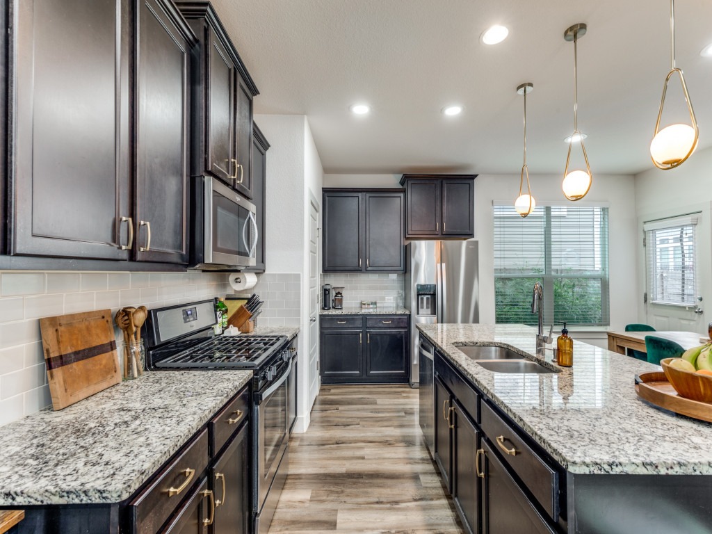 2204 Montague Street Austin, TX 78741 - Photo 14 of 25 a kitchen with stainless steel appliances granite countertop a sink a stove and a wooden floors
