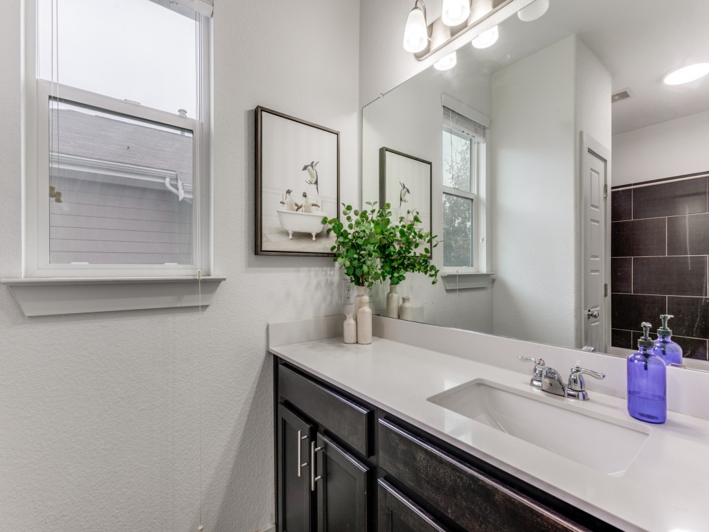 2204 Montague Street Austin, TX 78741 - Photo 21 of 25 a bathroom with a granite countertop sink and a mirror