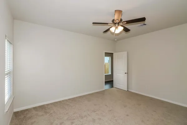 a view of an empty room and a ceiling fan