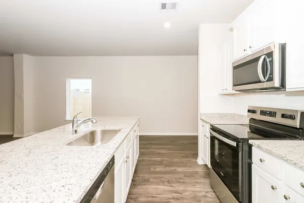 a kitchen with sink stove microwave and refrigerator