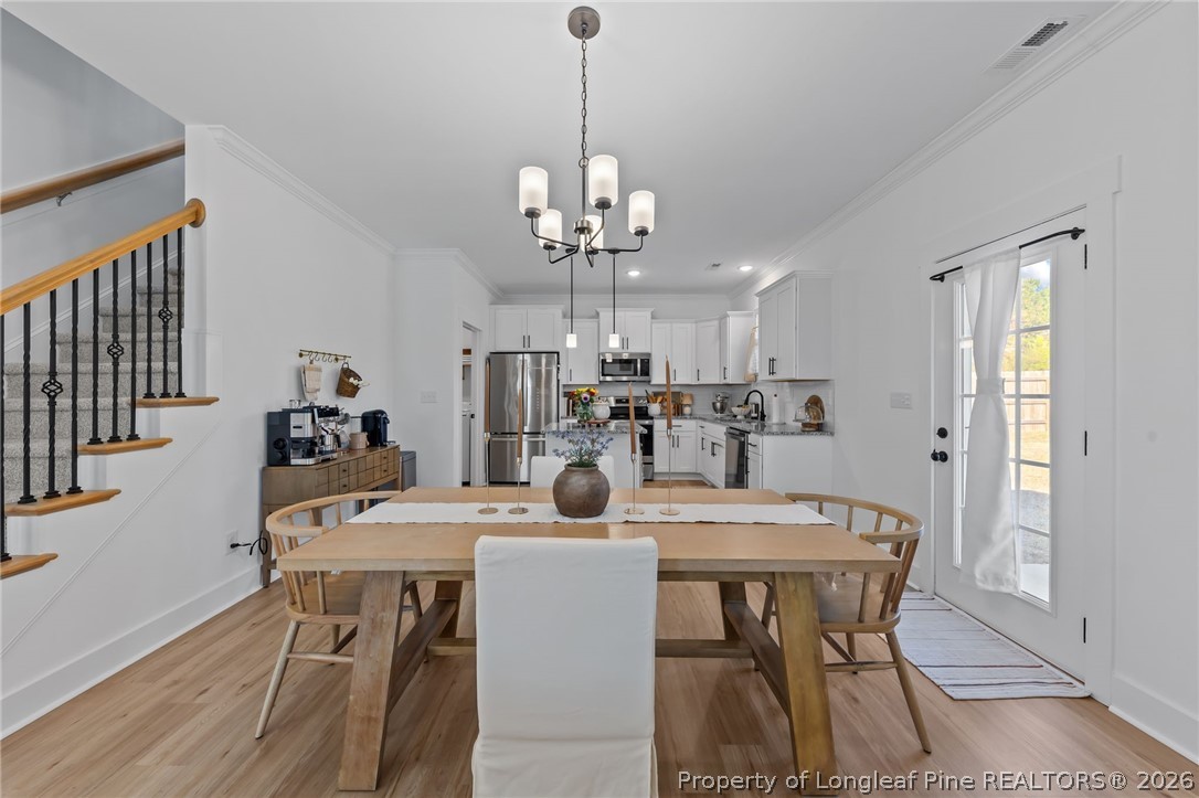278 Slade Corner Road Raeford, NC 28376 - Photo 11 of 39 a view of a dining room with furniture and a chandelier