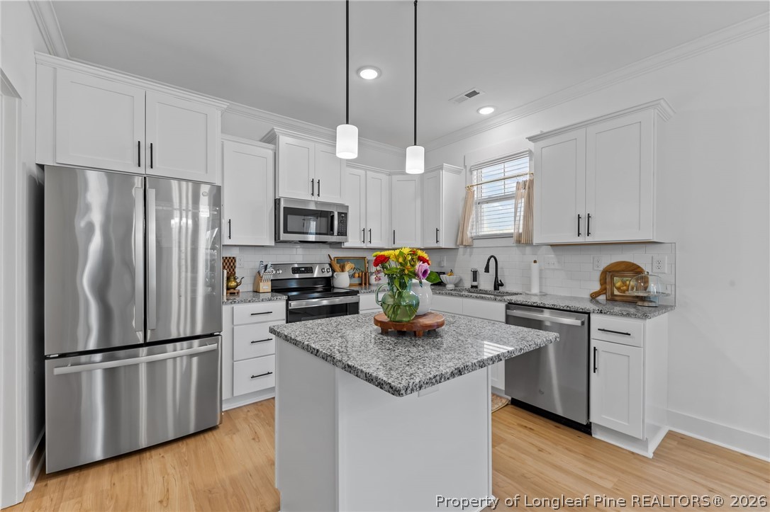 278 Slade Corner Road Raeford, NC 28376 - Photo 12 of 39 a kitchen with granite countertop stainless steel appliances a refrigerator a stove a sink cabinets and living room view
