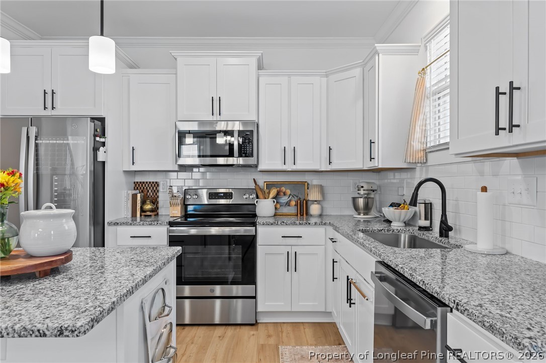 278 Slade Corner Road Raeford, NC 28376 - Photo 13 of 39 a kitchen with stainless steel appliances granite countertop a sink stove and refrigerator