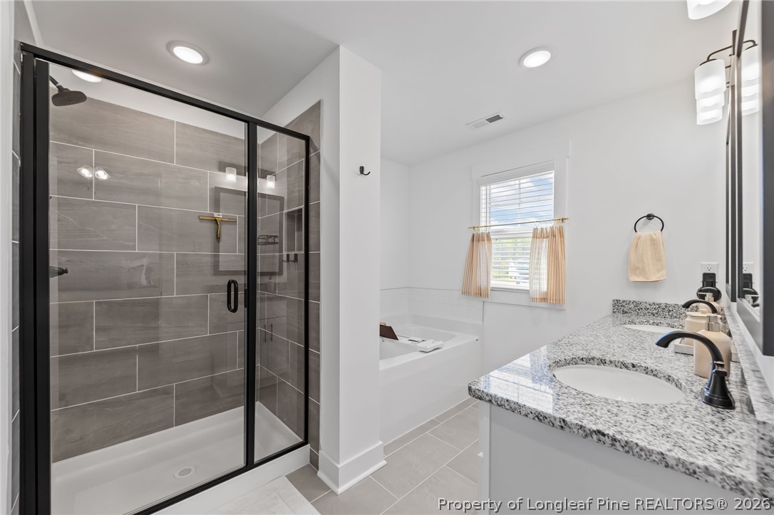 278 Slade Corner Road Raeford, NC 28376 - Photo 20 of 39 a bathroom with a granite countertop sink a mirror and a bathtub