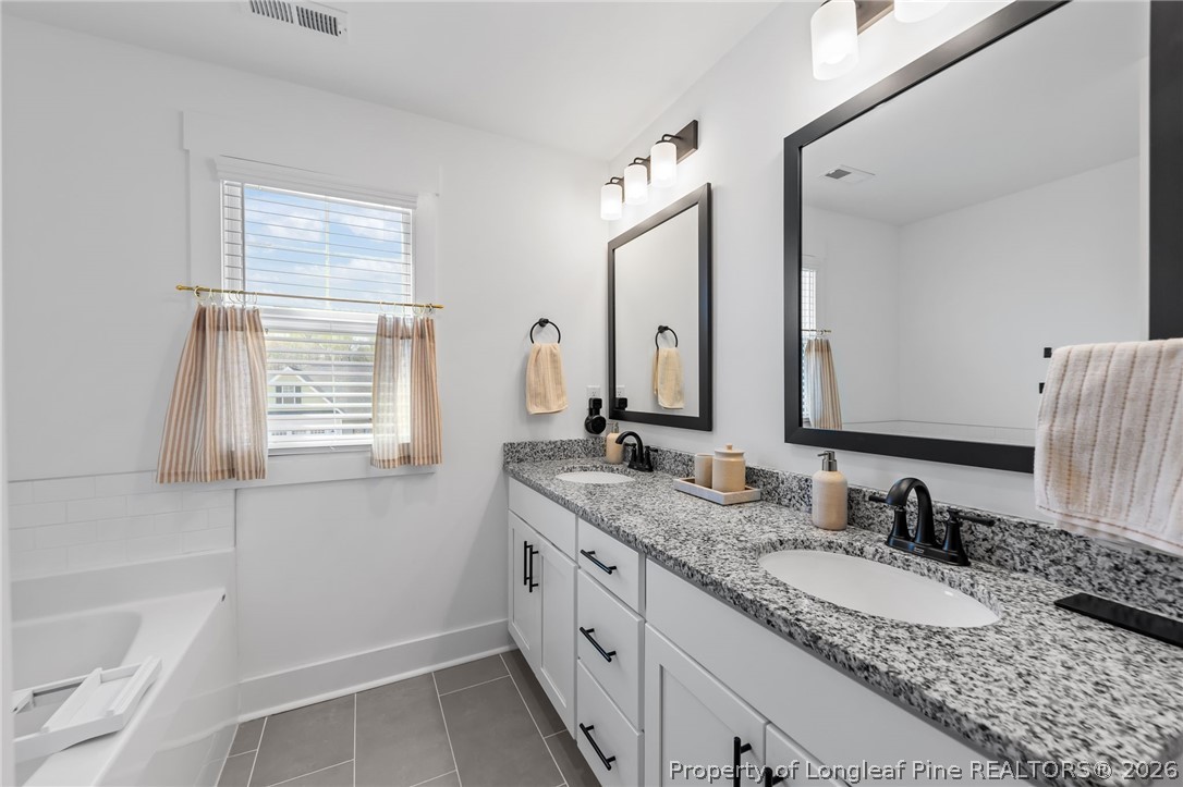 278 Slade Corner Road Raeford, NC 28376 - Photo 21 of 39 a bathroom with a granite countertop sink and a bathtub