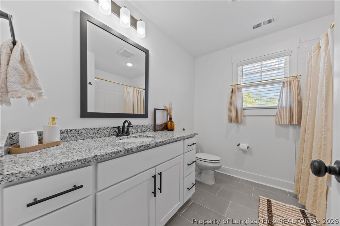 278 Slade Corner Road Raeford, NC 28376 - Photo 26 of 39 a bathroom with a granite countertop toilet sink and mirror