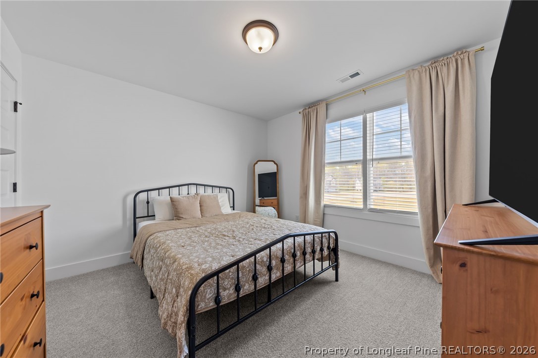278 Slade Corner Road Raeford, NC 28376 - Photo 29 of 39 a bedroom with a bed lamp and a window