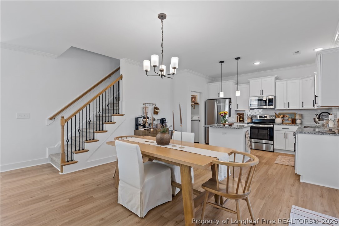 278 Slade Corner Road Raeford, NC 28376 - Photo 10 of 39 a dining room with furniture a chandelier and wooden floor