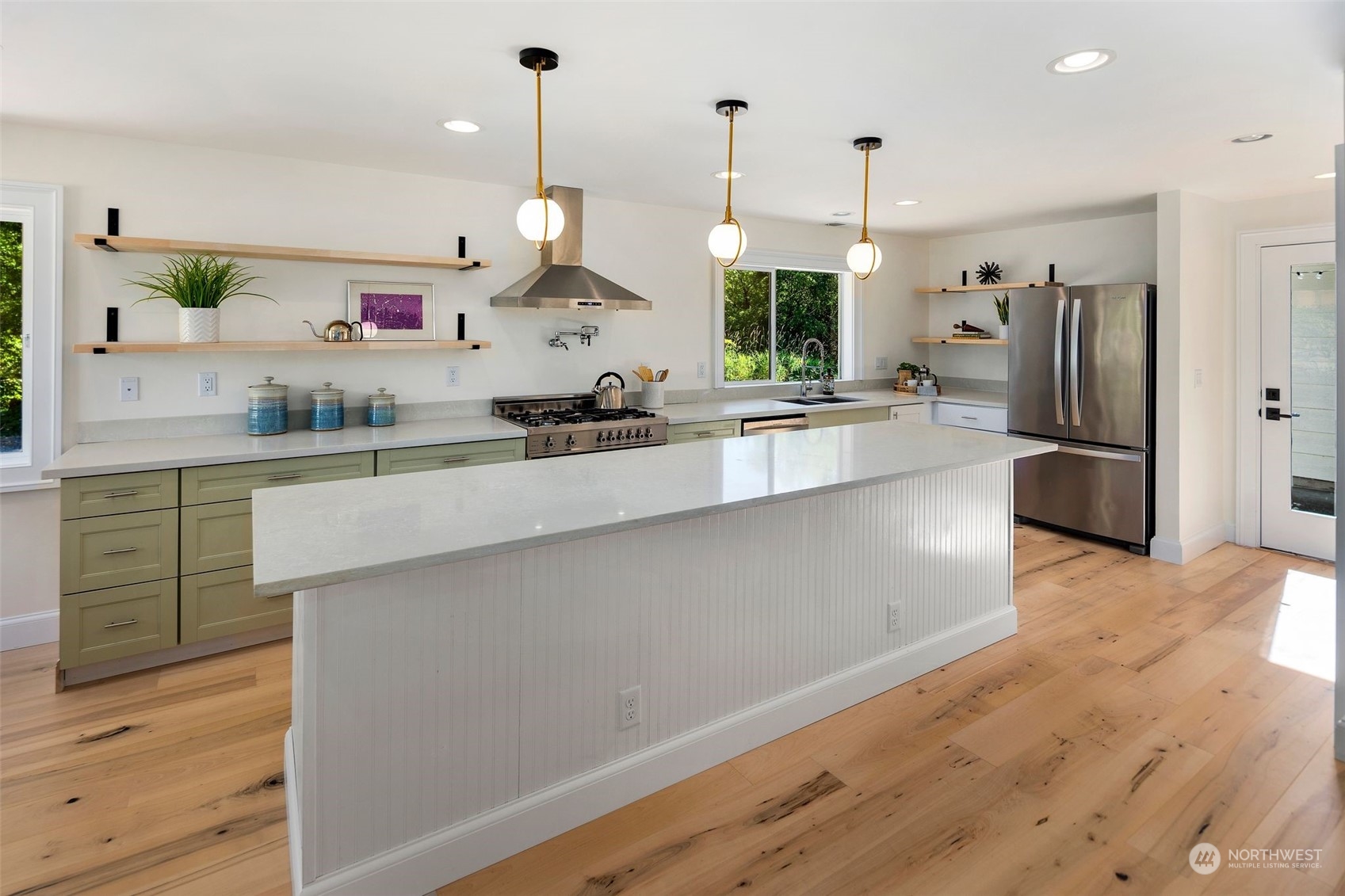 24124 7th Avenue Southeast Bothell, WA 98021 - Photo 19 of 40 a large kitchen with stainless steel appliances a large counter top a stove a sink a refrigerator and a wooden floor
