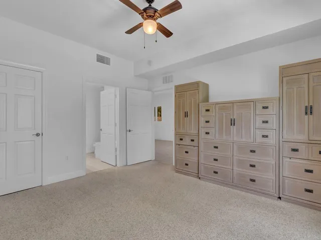 a view of a bedroom with cabinet cabinet and windows