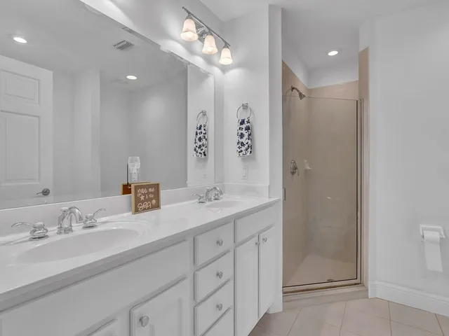 a bathroom with double vanity sink and a mirror