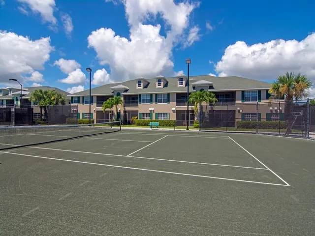 a view of a tennis ground with large trees