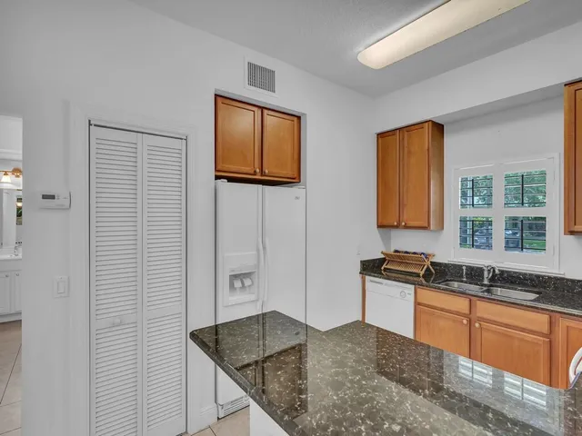 a kitchen with granite countertop a sink and a stove top oven