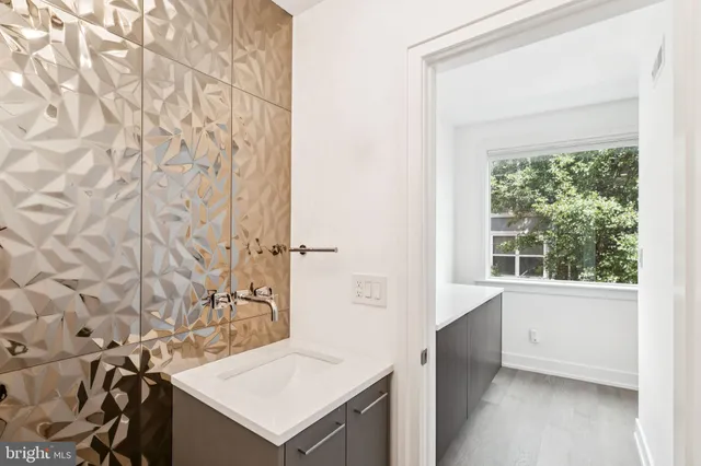 a kitchen with stainless steel appliances a sink a counter top space a large window and stainless steel appliances