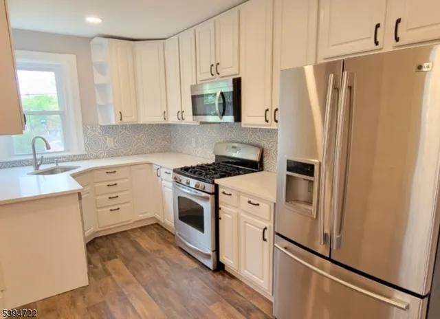 a kitchen with white cabinets and white appliances