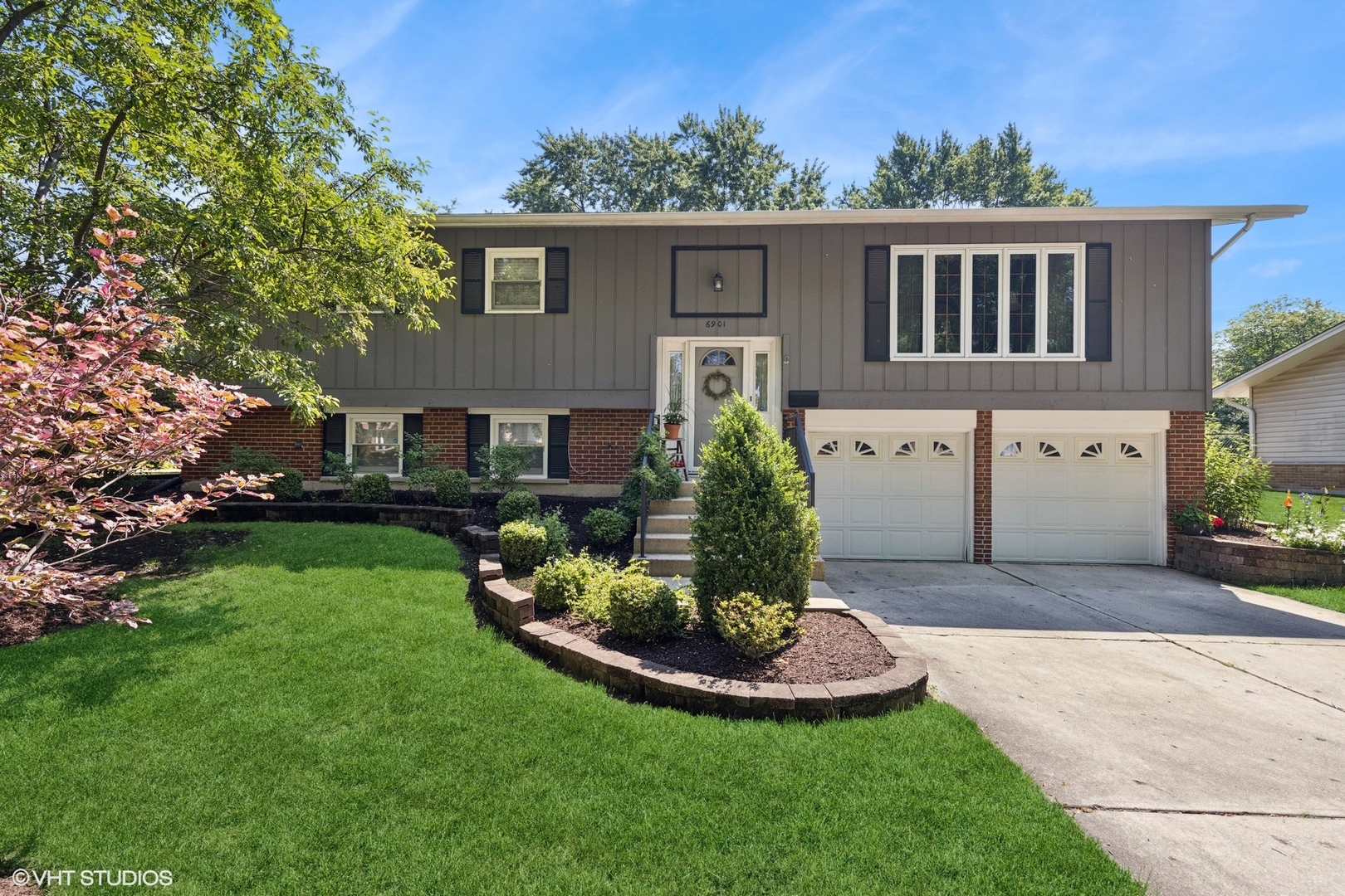 6901 Meadow Crest Drive Downers Grove, IL 60516 - Photo 1 of 42 a front view of a house with a yard and trees