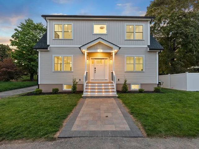 a front view of a house with a yard and trees