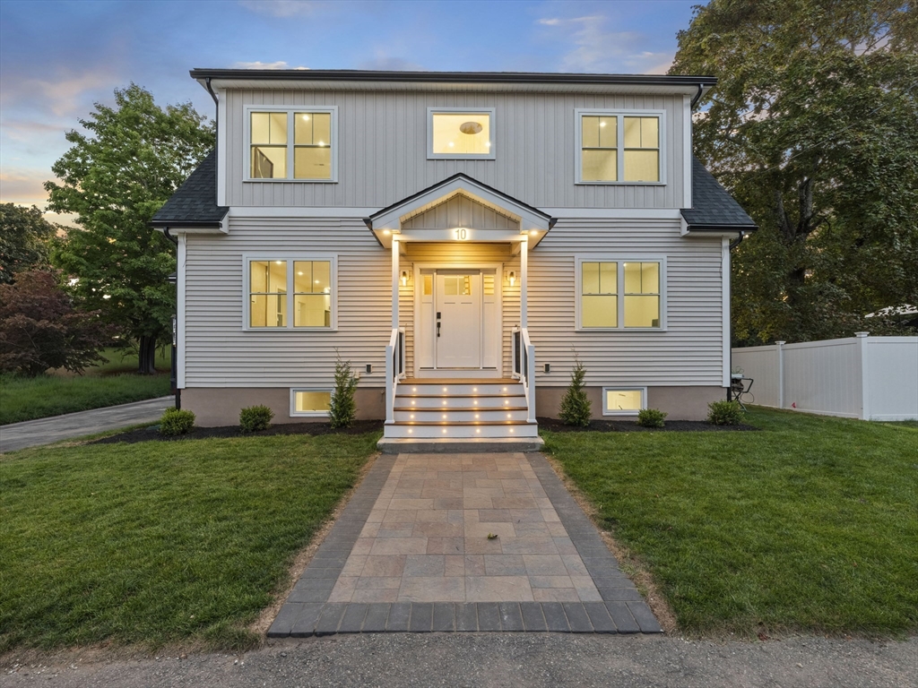 a front view of a house with a yard and trees