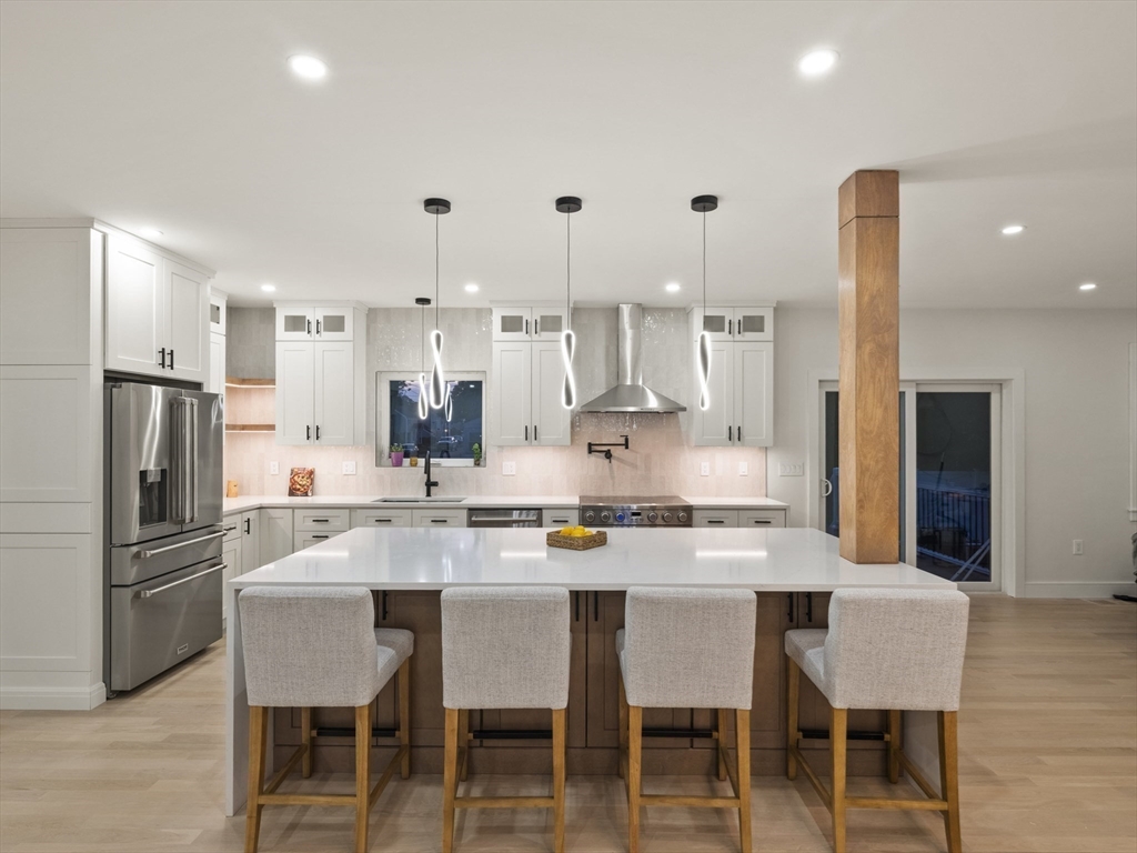 10 Ames Street Wakefield, MA 01880 - Photo 11 of 42 a kitchen with stainless steel appliances kitchen island granite countertop a table and chairs