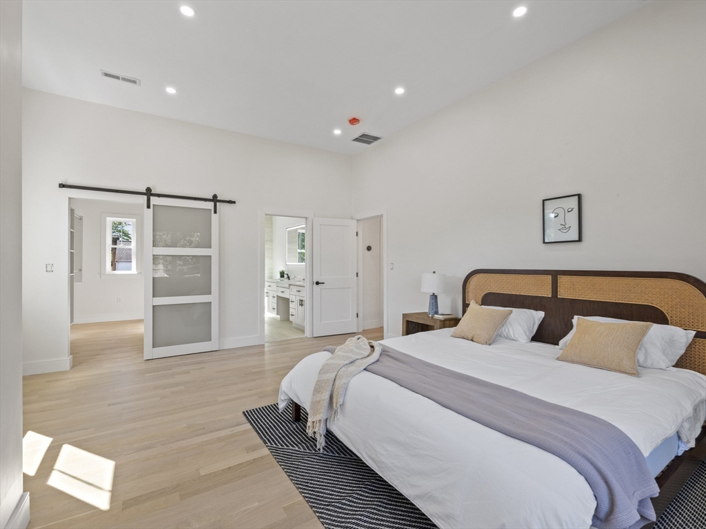 10 Ames Street Wakefield, MA 01880 - Photo 28 of 42 a bedroom with a large bed and a chandelier