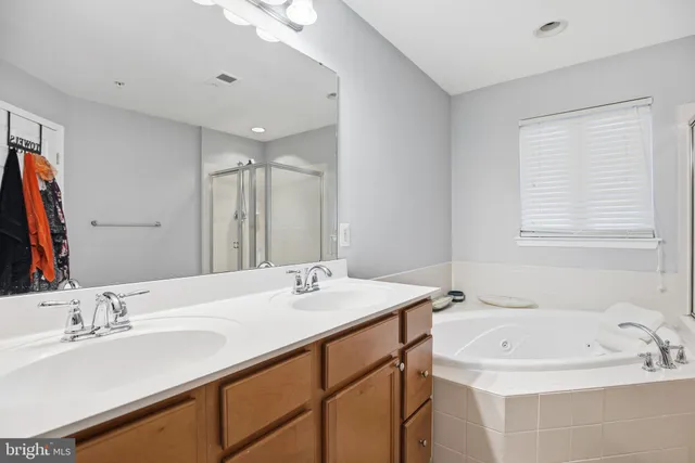 a spacious bathroom with a tub sink and mirror
