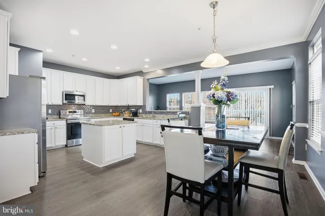 a kitchen with refrigerator cabinets dining table and chairs