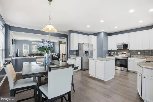 a kitchen with granite countertop white cabinets and stainless steel appliances