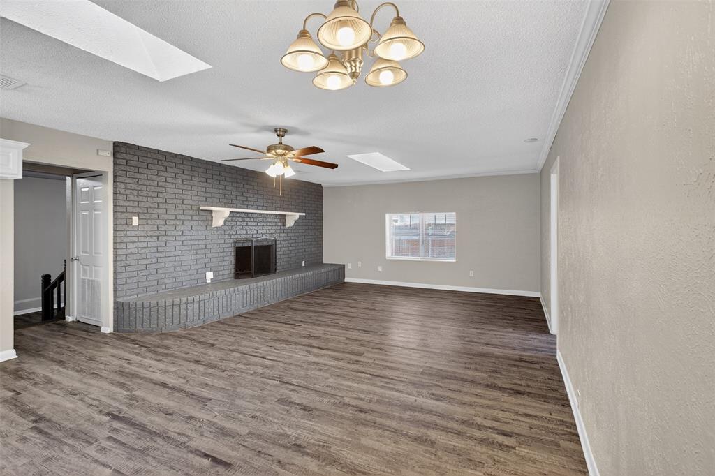 701 Harrison Lane Hurst, TX 76053 - Photo 14 of 29 an empty room with wooden floor a ceiling fan and windows