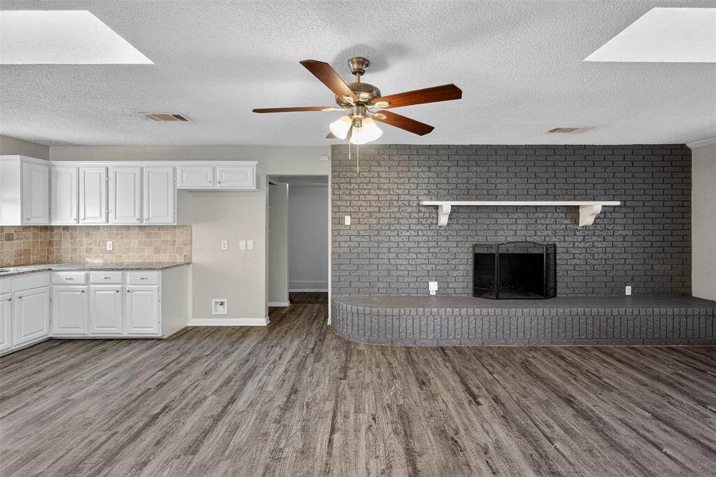 701 Harrison Lane Hurst, TX 76053 - Photo 21 of 29 a living room with stainless steel appliances wooden floor and a fireplace