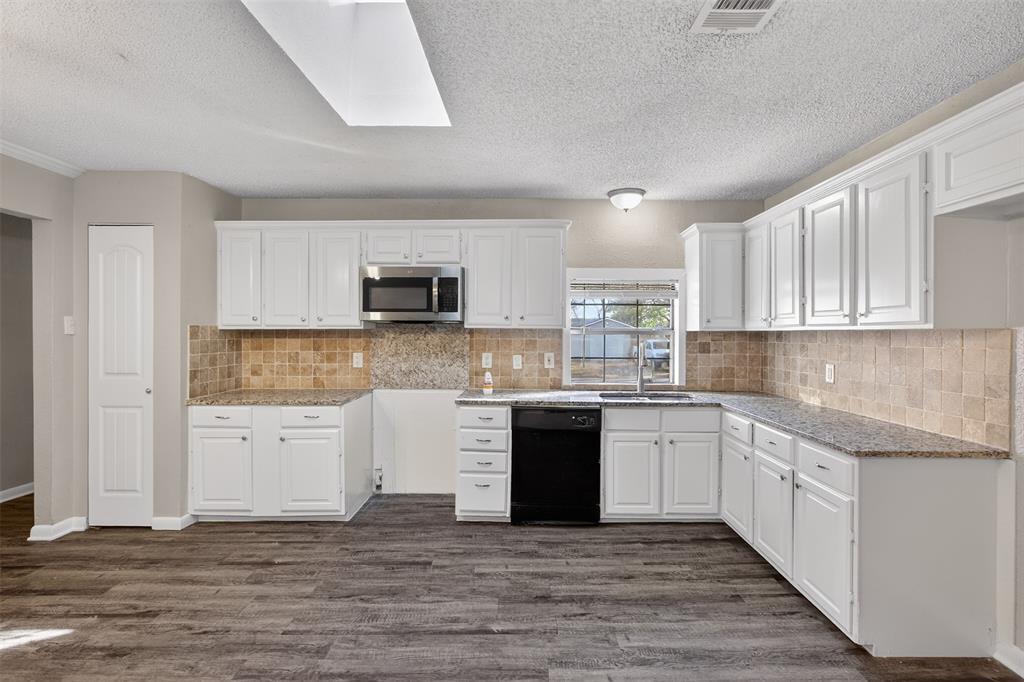 701 Harrison Lane Hurst, TX 76053 - Photo 23 of 29 a kitchen with granite countertop a sink and cabinets