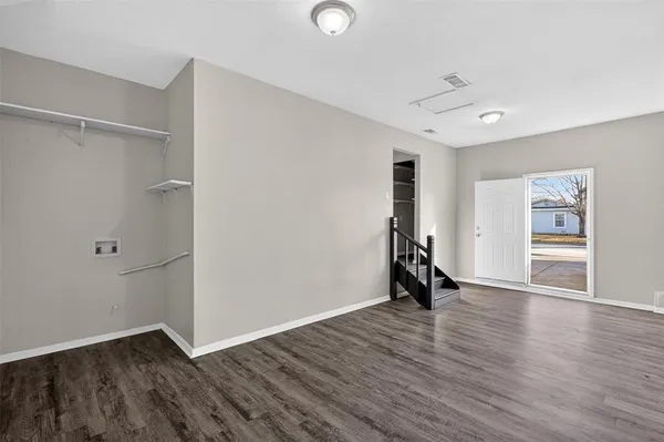 an empty room with wooden floor and a window