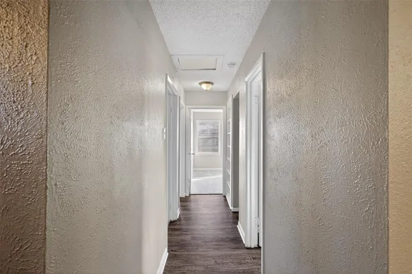 a view of a hallway with wooden floor