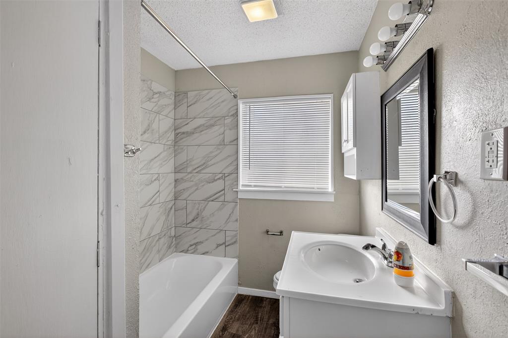 701 Harrison Lane Hurst, TX 76053 - Photo 6 of 29 a bathroom with a tub sink and mirror