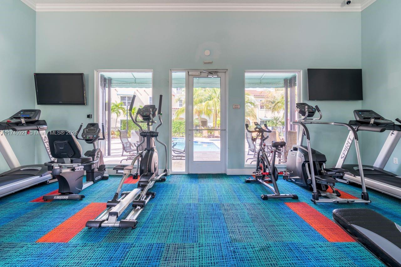 1799 Northwest 124th Way, Unit 1799 Pembroke Pines, FL 33028 - Photo 8 of 40 a room with gym equipment and a flat screen tv