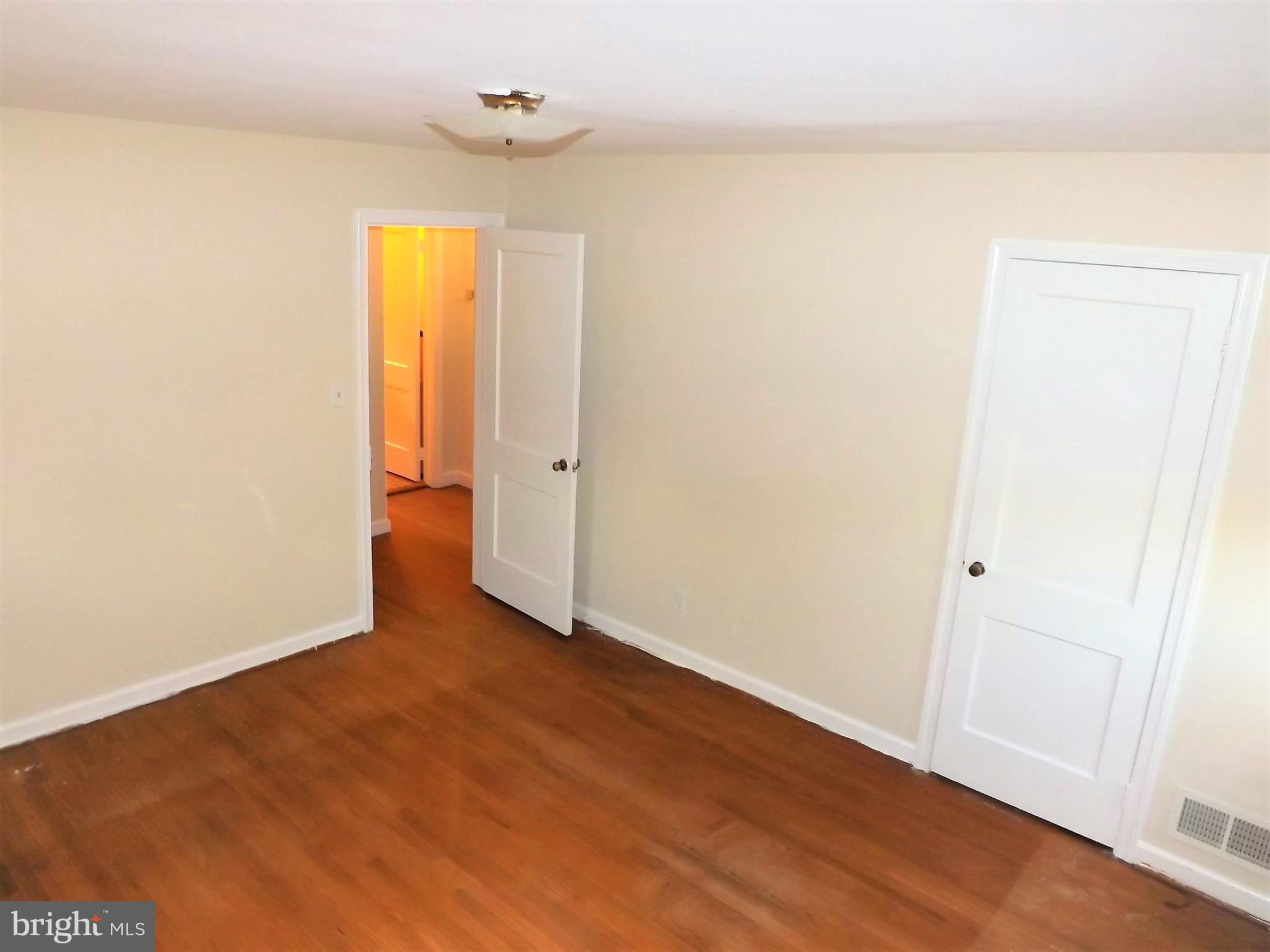 11936 Bluhill Road Silver Spring, MD 20902 - Photo 14 of 30 a view of an empty room with wooden floor and a window