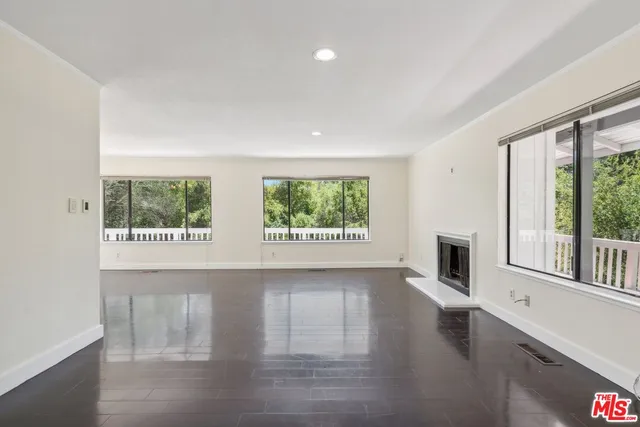 a view of a hallway with wooden floor and a window