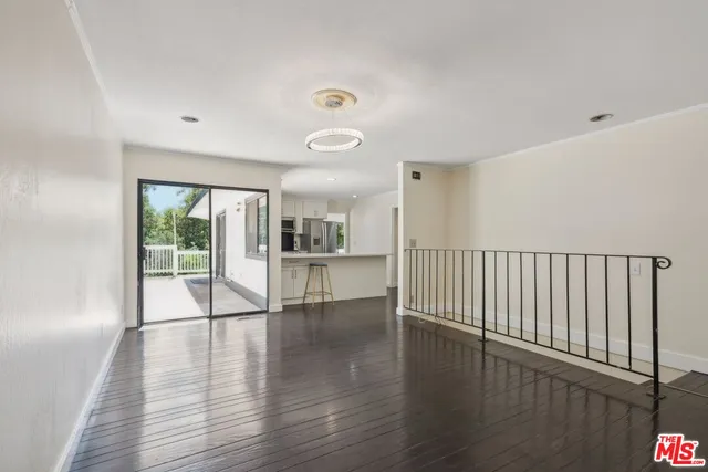 a view of empty room with wooden floor and windows
