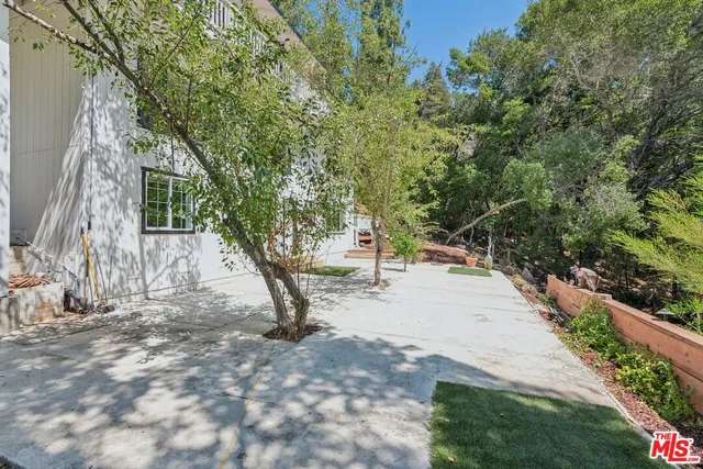 an aerial view of house with yard and mountain view in back